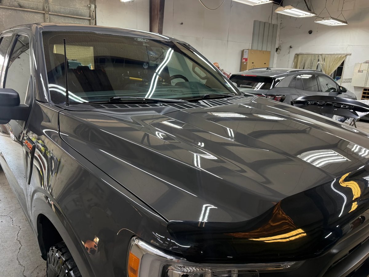 Aluminum Ford F-150 hood after paintless hail dent repair at DG Collision Center Lewisville TX &mdash; factory paint preserved