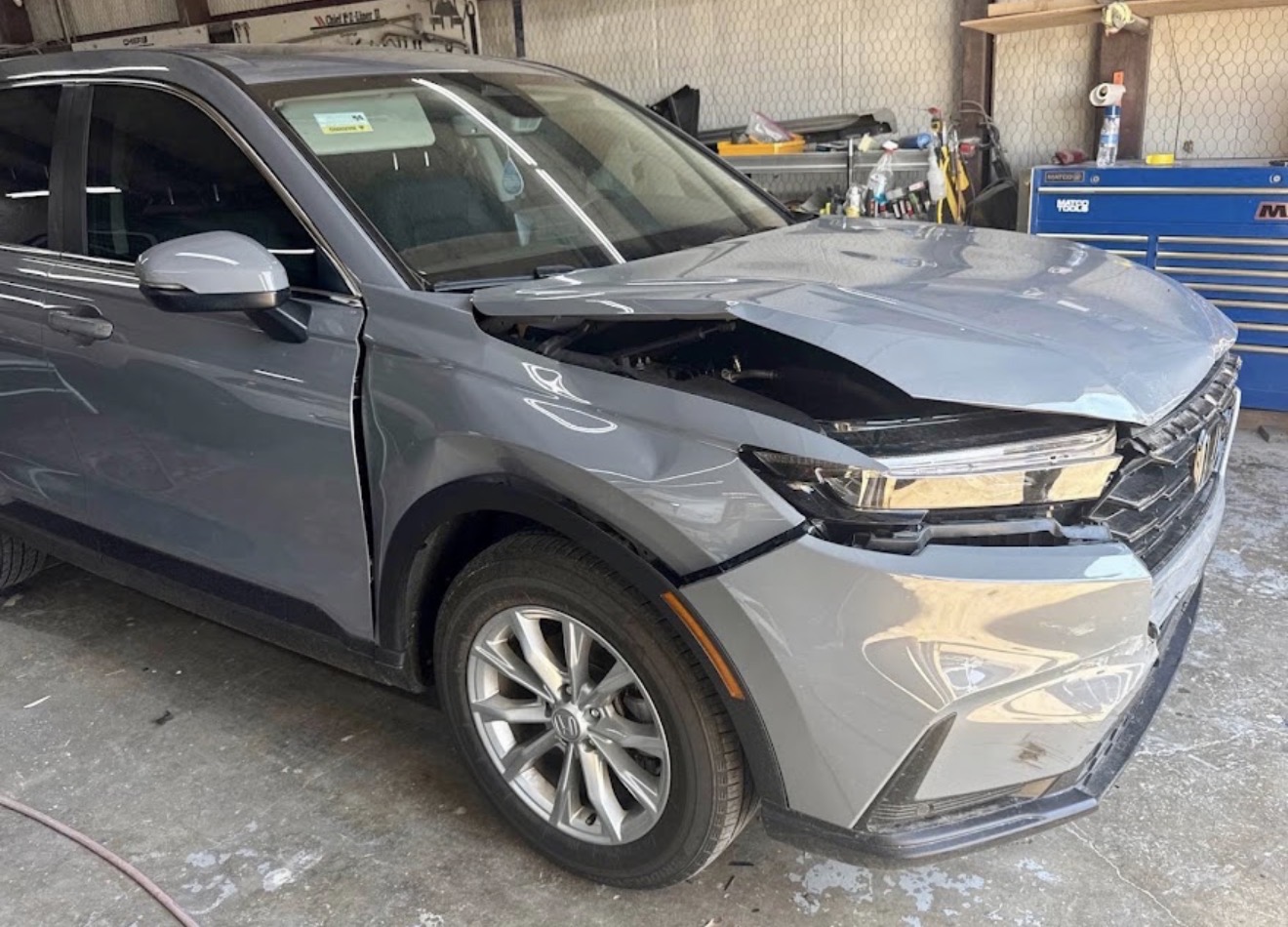 Customer's Honda CR-V with front bumper, hood, and fender damage before repair at DG Collision Center in Lewisville, TX