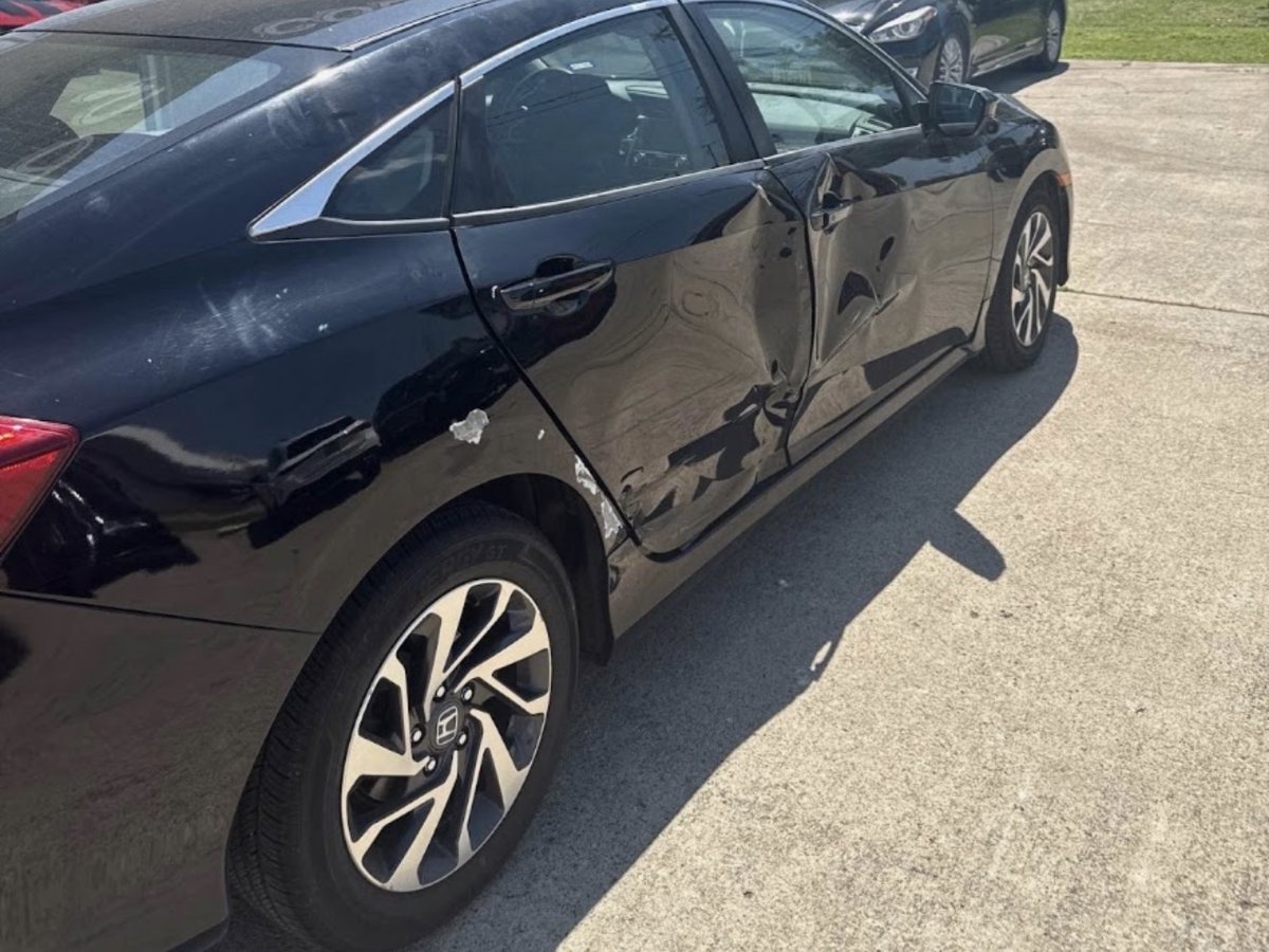 Side-impact collision damage before repair — Honda Civic with dented doors and quarter panel at DG Collision Center Lewisville TX